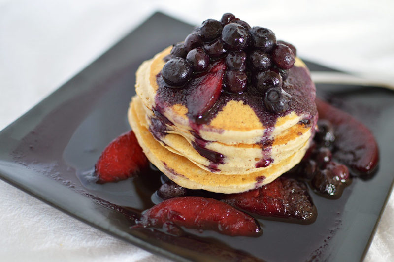 Pancakes with ground flax seed, sweetened with Truvia and brown sugar topped with a warm blueberry-peach-cinnamon sauce from thatsquareplate.com