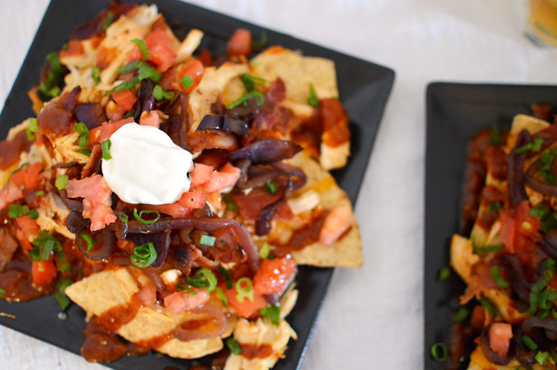 The homemade root beer barbecue sauce is what MAKES this dish! Warm BBQ chicken, cheese, caramelized onions and bacon top these sweet, semi-spicy nachos. Garnish with tomatoes, green onions, and sour cream if you want to max out the flavor! Recipe from thatquareplate.com