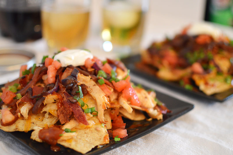 The homemade root beer barbecue sauce is what MAKES this dish! Warm BBQ chicken, cheese, caramelized onions and bacon top these sweet, semi-spicy nachos. Garnish with tomatoes, green onions, and sour cream if you want to max out the flavor! Recipe from thatquareplate.com