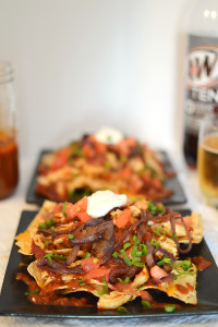 The homemade root beer barbecue sauce is what MAKES this dish! Warm BBQ chicken, cheese, caramelized onions and bacon top these sweet, semi-spicy nachos. Garnish with tomatoes, green onions, and sour cream if you want to max out the flavor! Recipe from thatquareplate.com